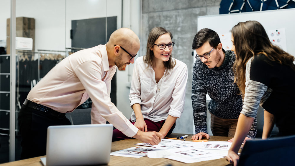 four young business people working on a project together