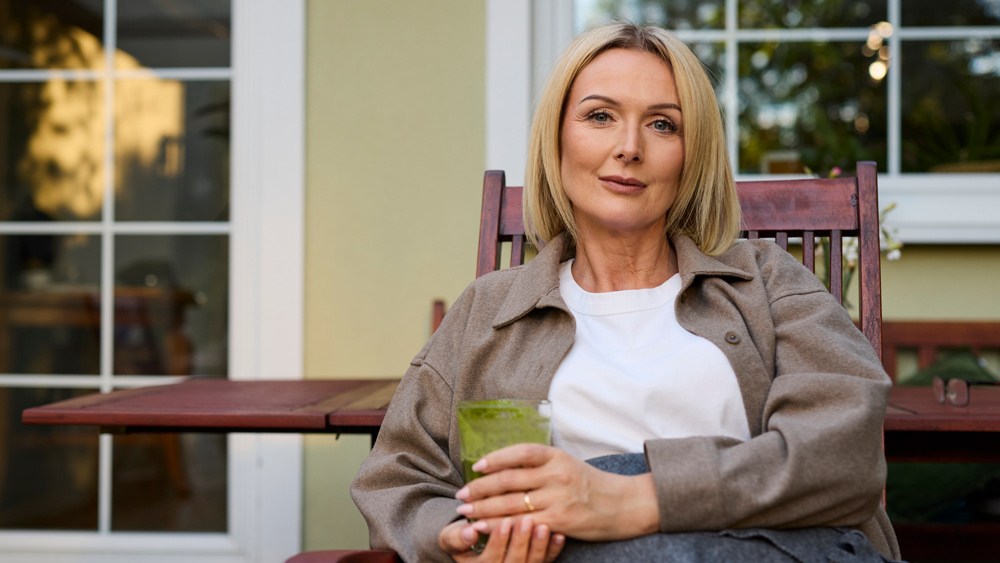 Woman sitting on porch with glass of water