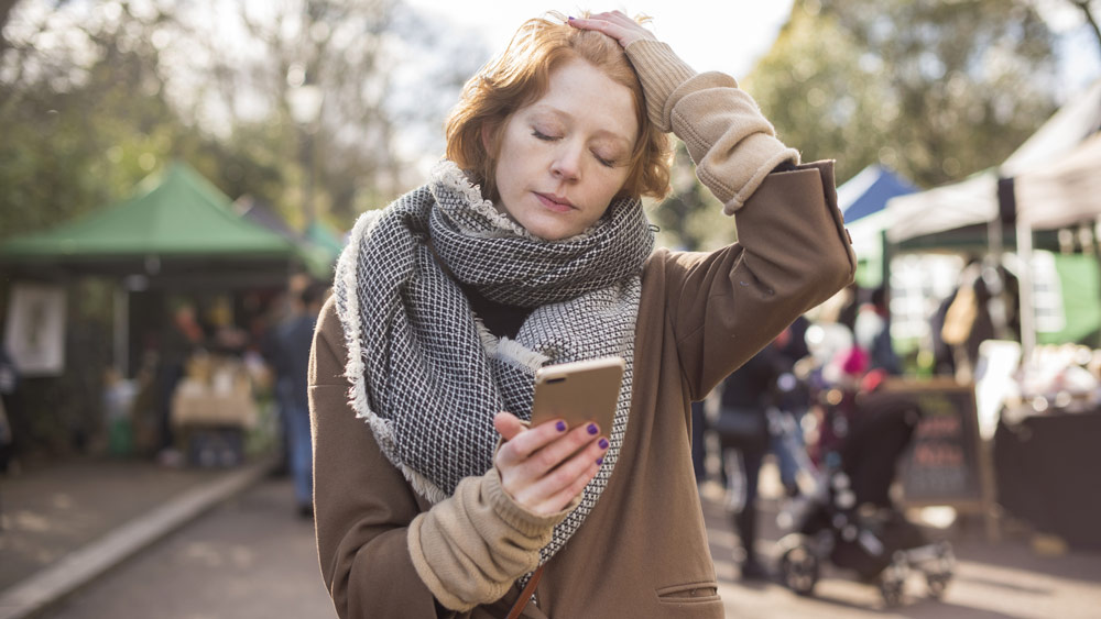 a woman staring into smartphone