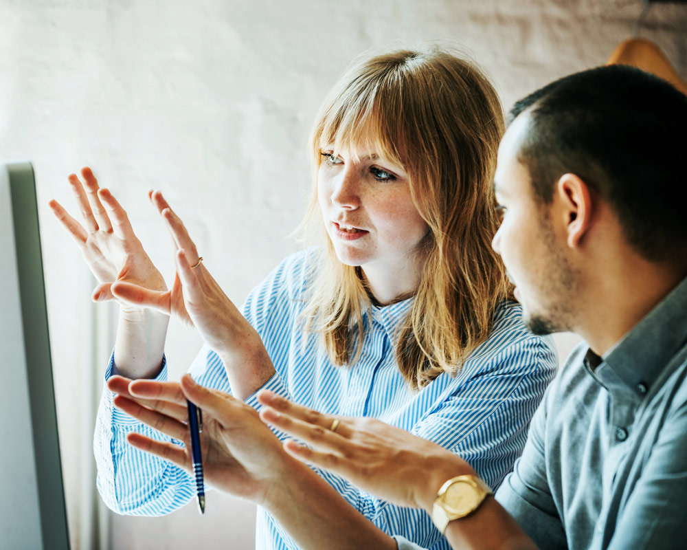 man and woman collaborating on work at a computer