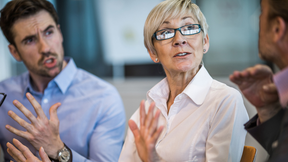 woman and two men arguing in office