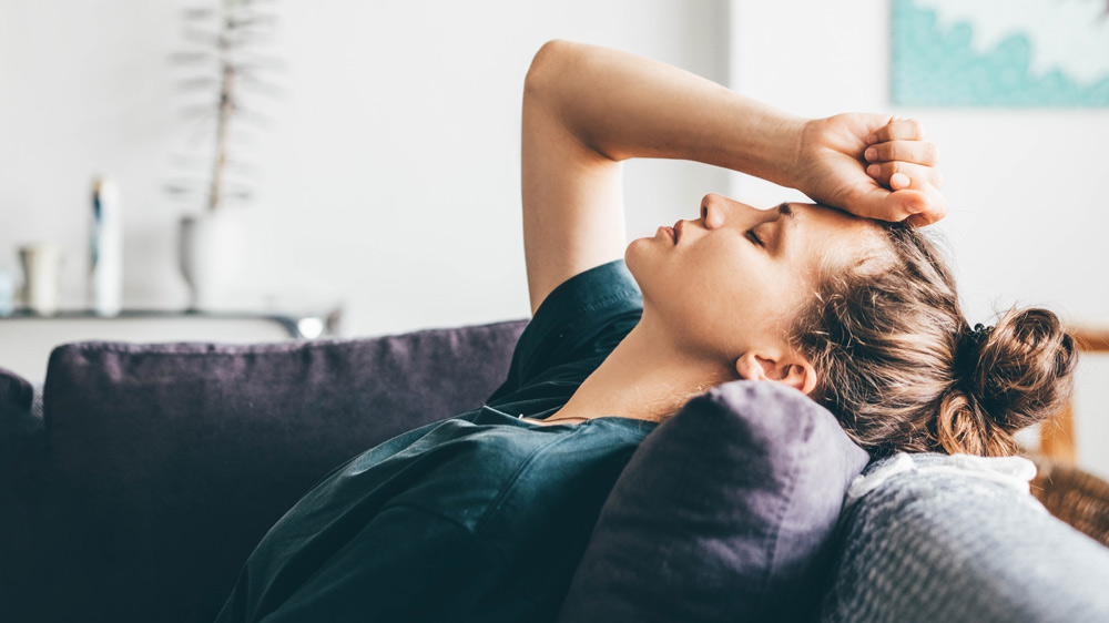 frustrated woman sitting on sofa at home