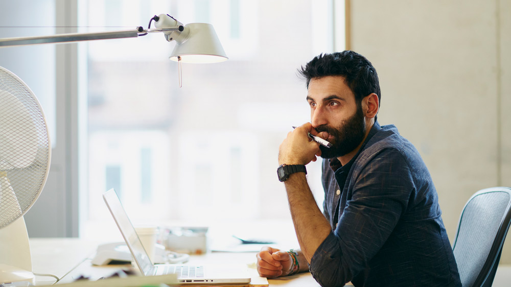 man sitting at computer thinking