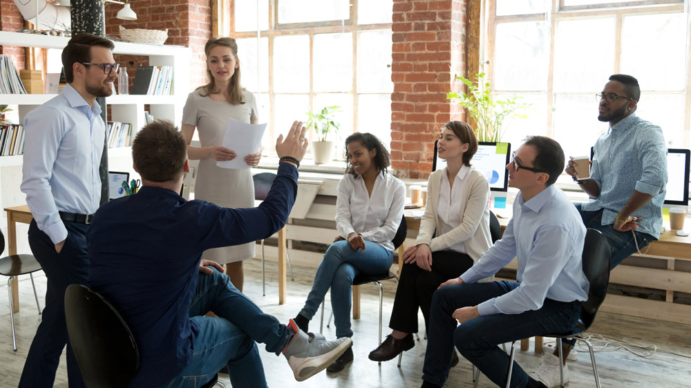 Male worker raise hand asking question at office teambuilding