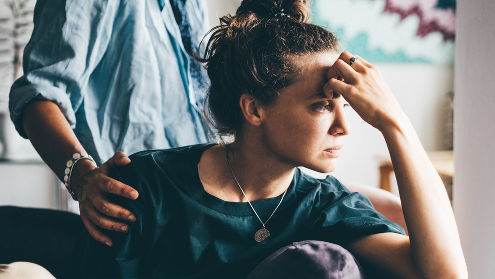 woman sitting on couch feeling sad or anxious