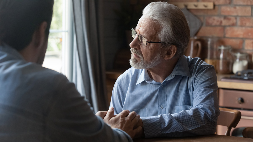 adult child talking with senior father