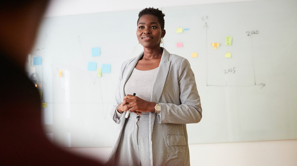 woman teaching a classroom of business professionals