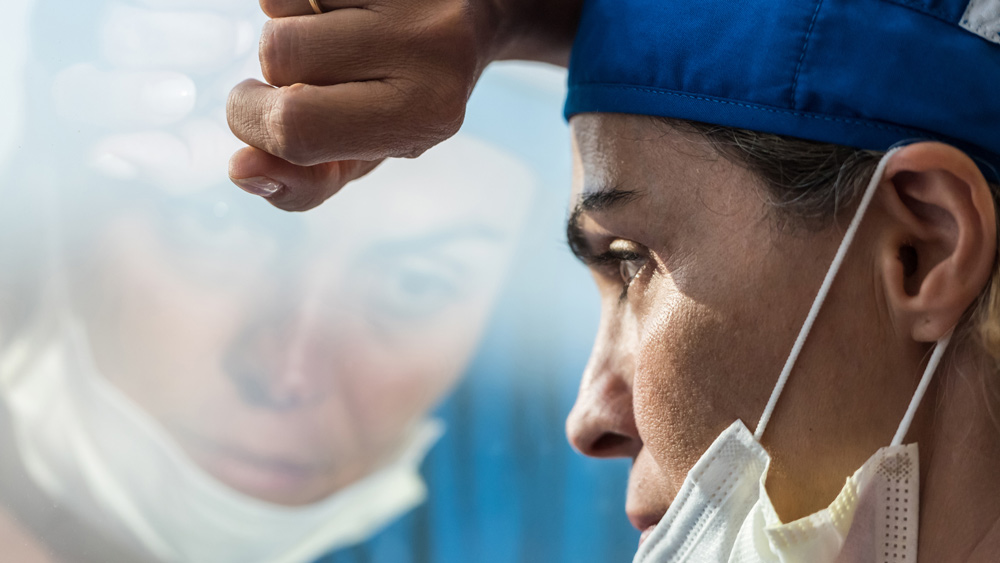 exhausted healthcare worker looking out window