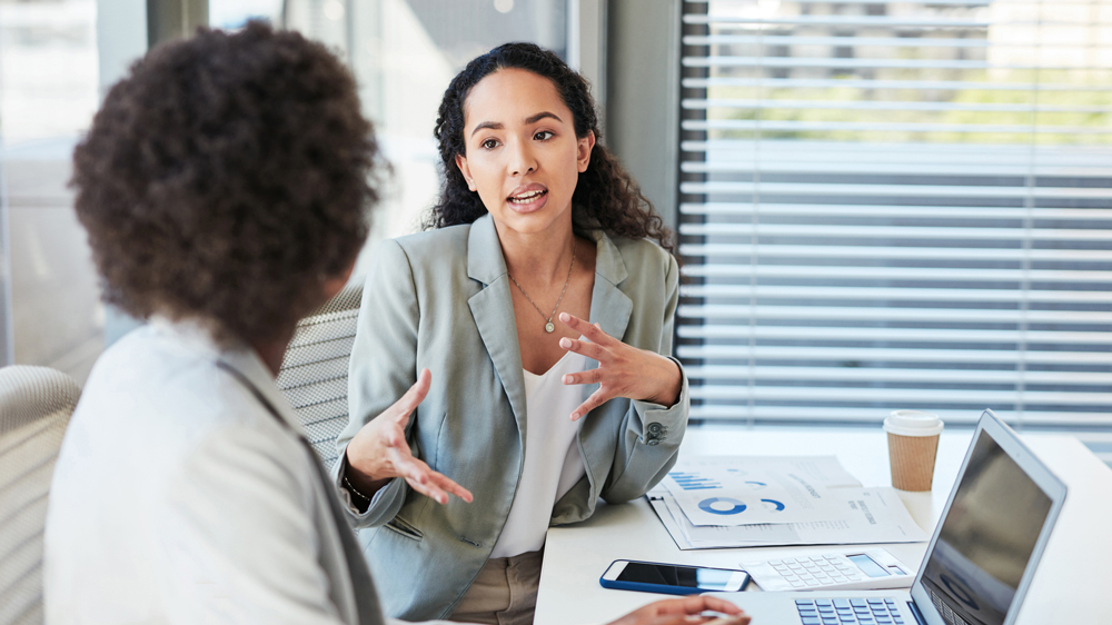 two women talking in a business office