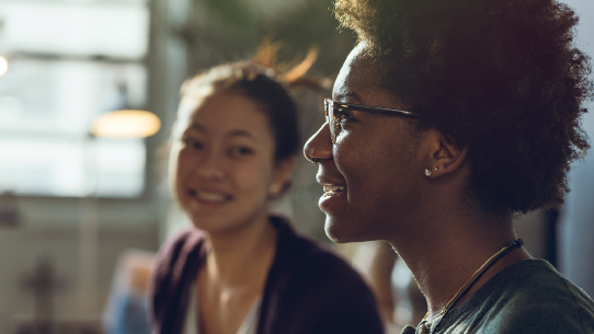 two people in a team meeting, smiling