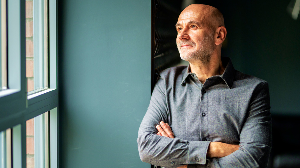 mature businessman in casual office looking out window thinking