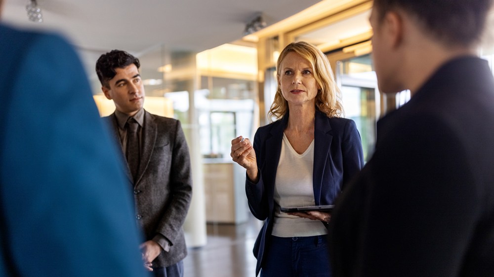 confident and stern female ceo with group of executives
