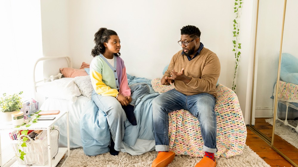 father talking with daughter in bedroom