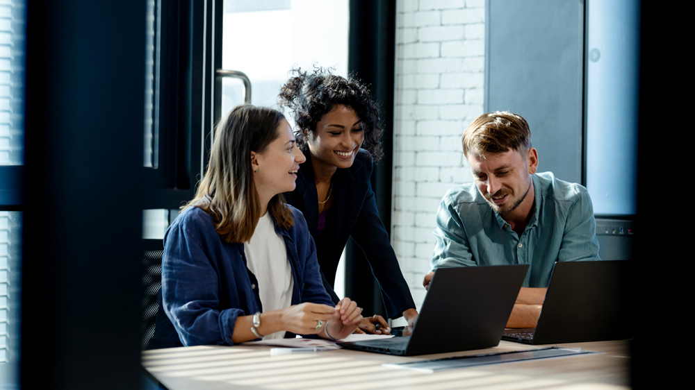 team of three people collaborating at desk