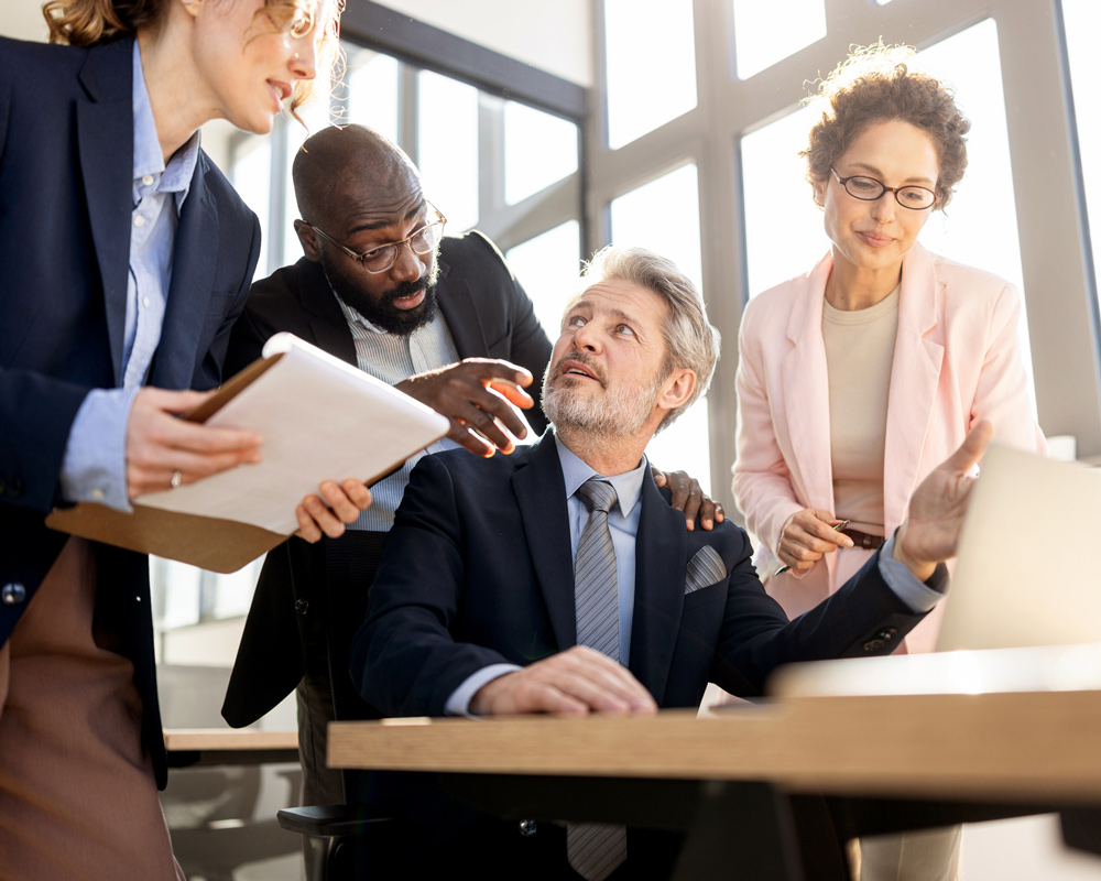 coworkers showing frustration with a senior male employee